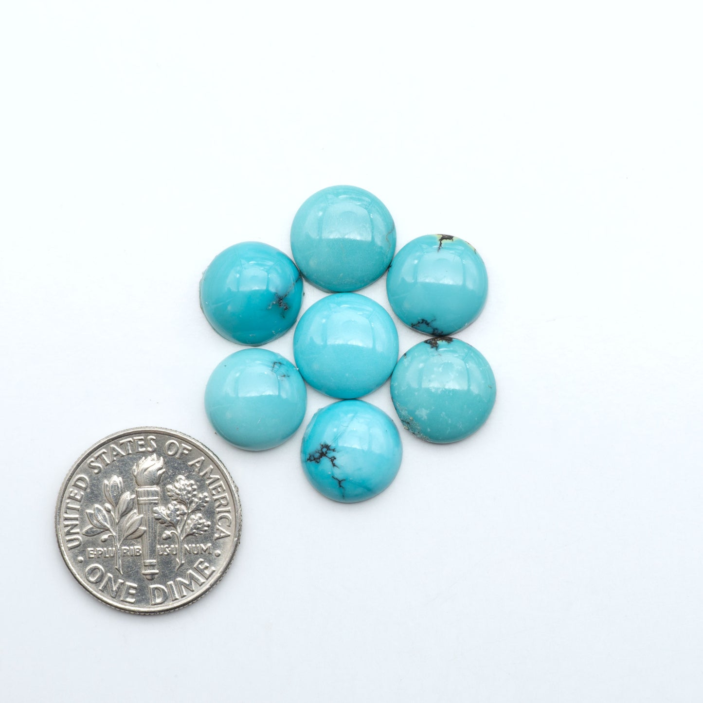 Hubei Cloud Mountain Turquoise cabochons, blue and green color with black matrix, polished stones on a white background with a US dime for scale