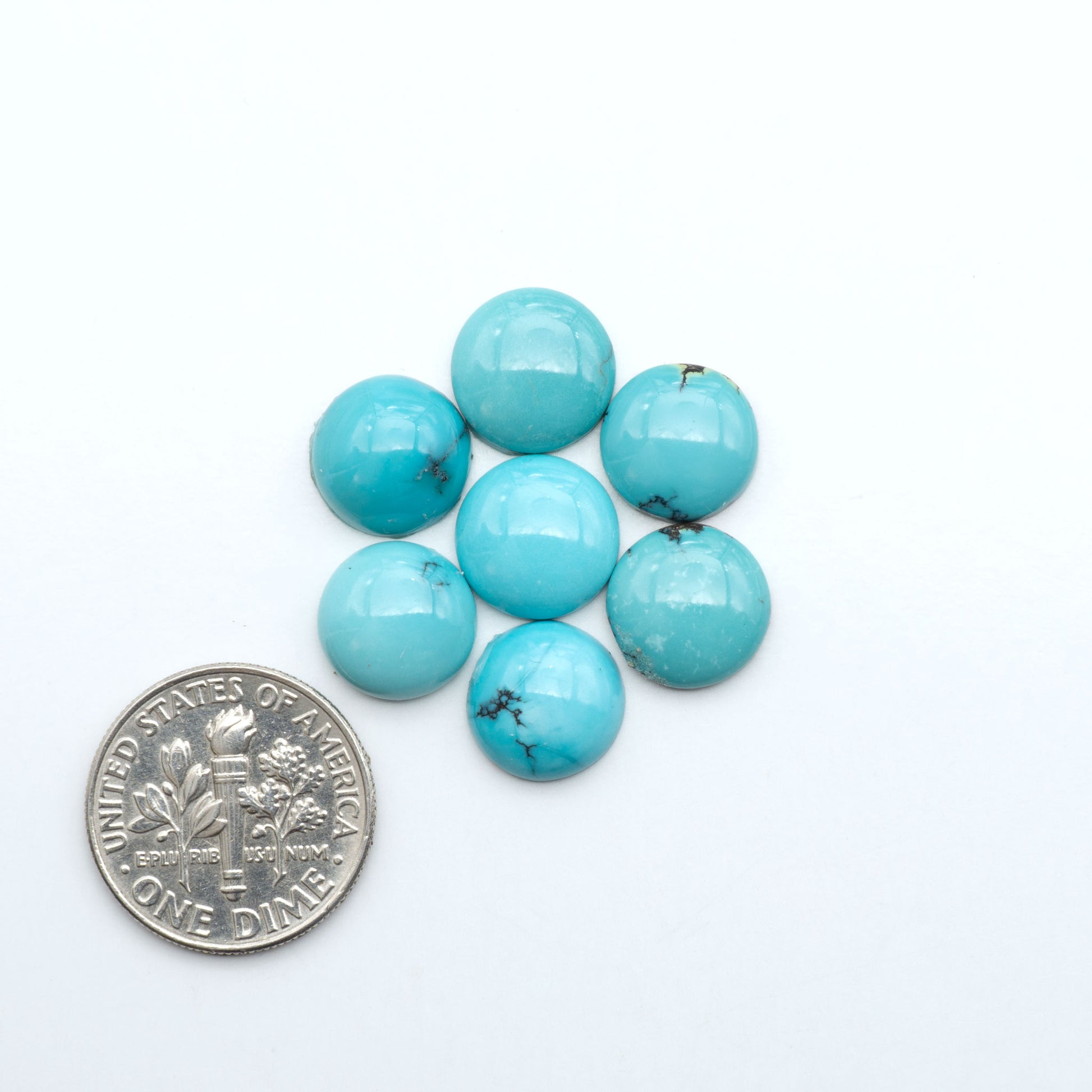 Hubei Cloud Mountain Turquoise cabochons, blue and green color with black matrix, polished stones on a white background with a US dime for scale