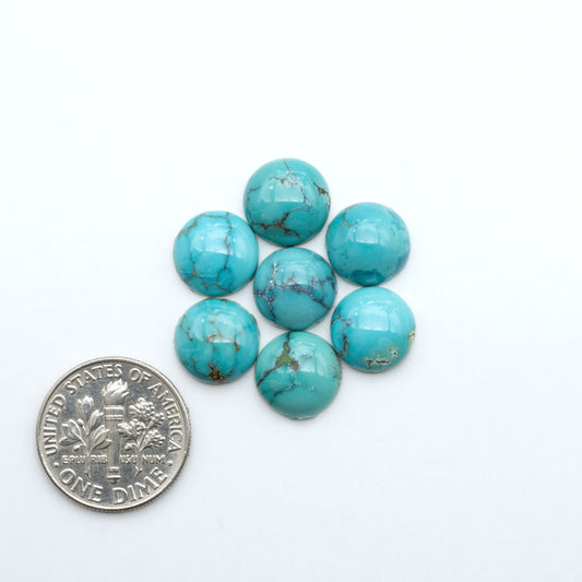 Hubei Cloud Mountain Turquoise cabochons, blue and green color with black matrix, polished stones on a white background with a US dime for scale
