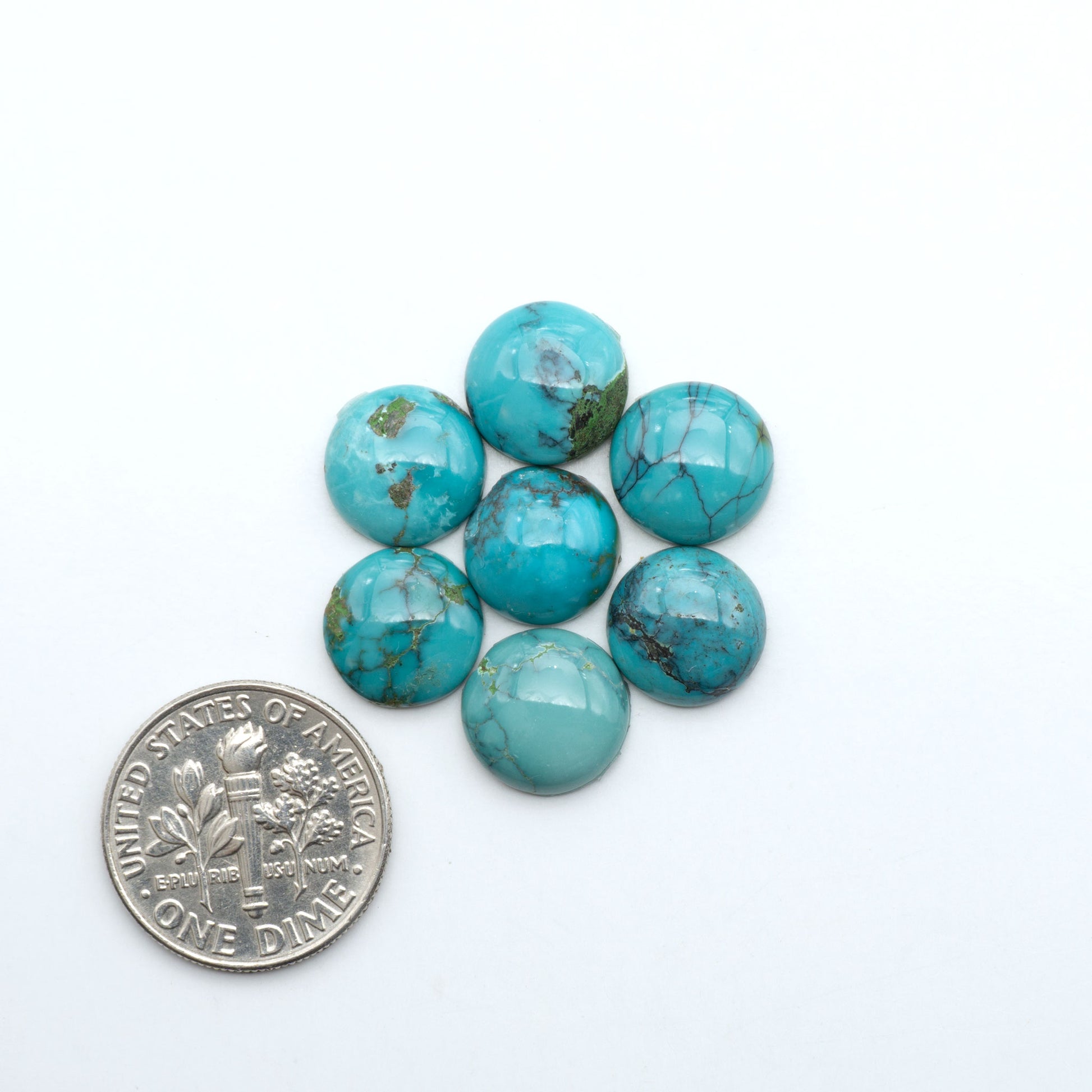Hubei Cloud Mountain Turquoise cabochons, blue and green color with black matrix, polished stones on a white background with a US dime for scale