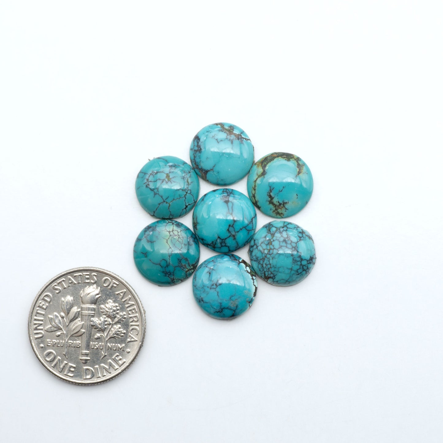 Hubei Cloud Mountain Turquoise cabochons, blue and green color with black matrix, polished stones on a white background with a US dime for scale