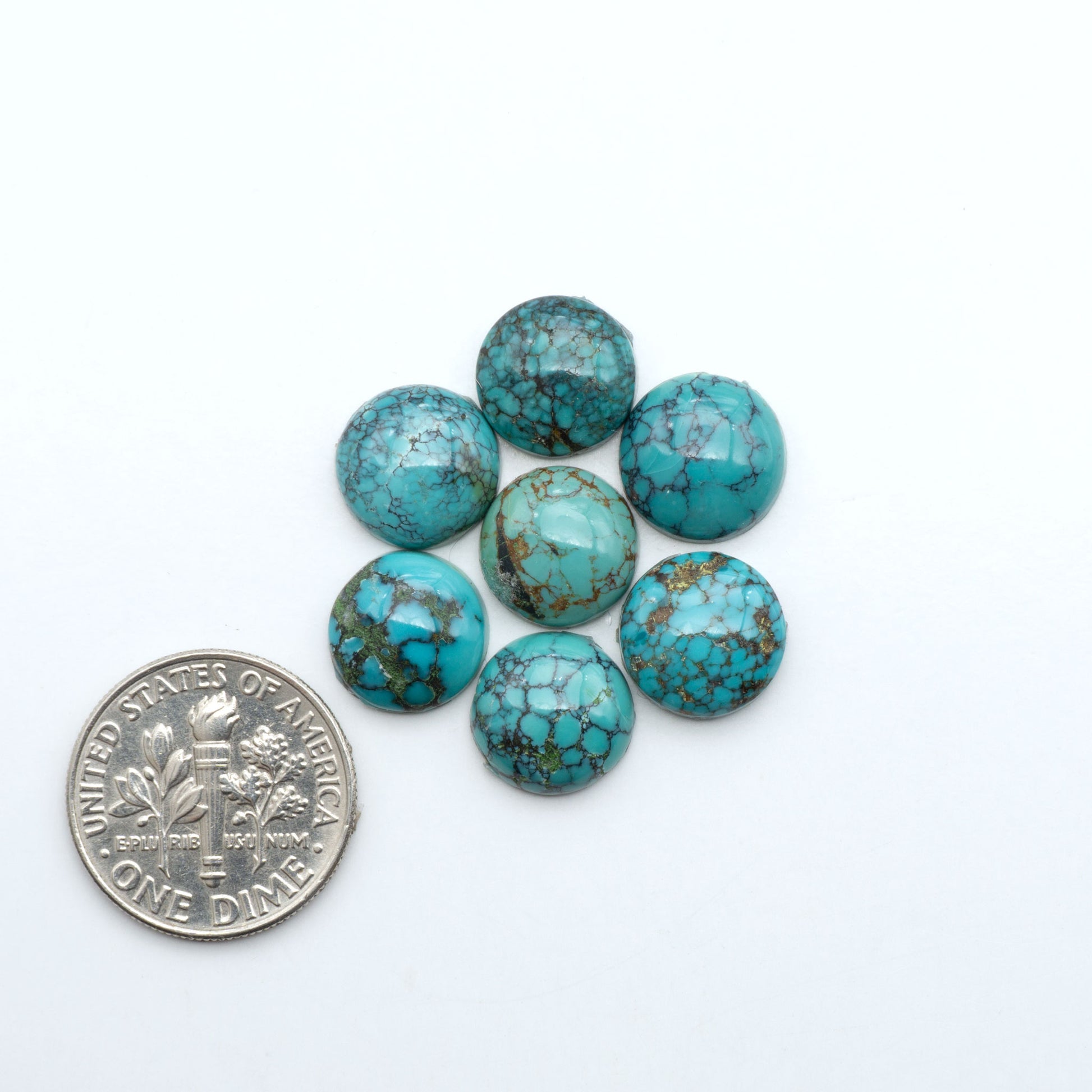 Hubei Cloud Mountain Turquoise cabochons, blue and green color with black matrix, polished stones on a white background with a US dime for scale