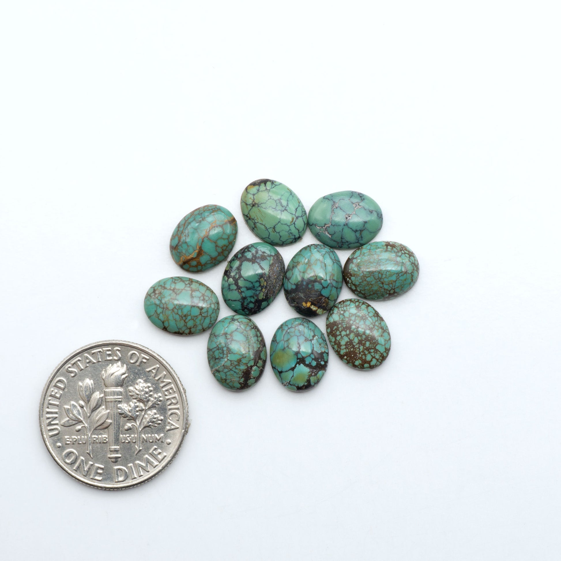 Hubei Cloud Mountain Turquoise cabochons, blue and green color with black matrix, polished stones on a white background with a US dime for scale
