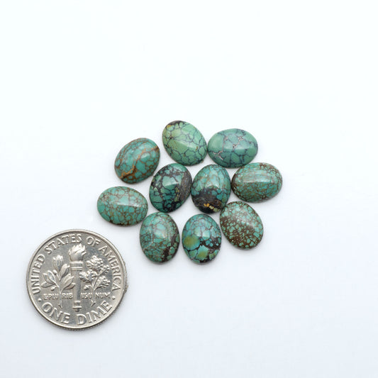 Hubei Cloud Mountain Turquoise cabochons, blue and green color with black matrix, polished stones on a white background with a US dime for scale