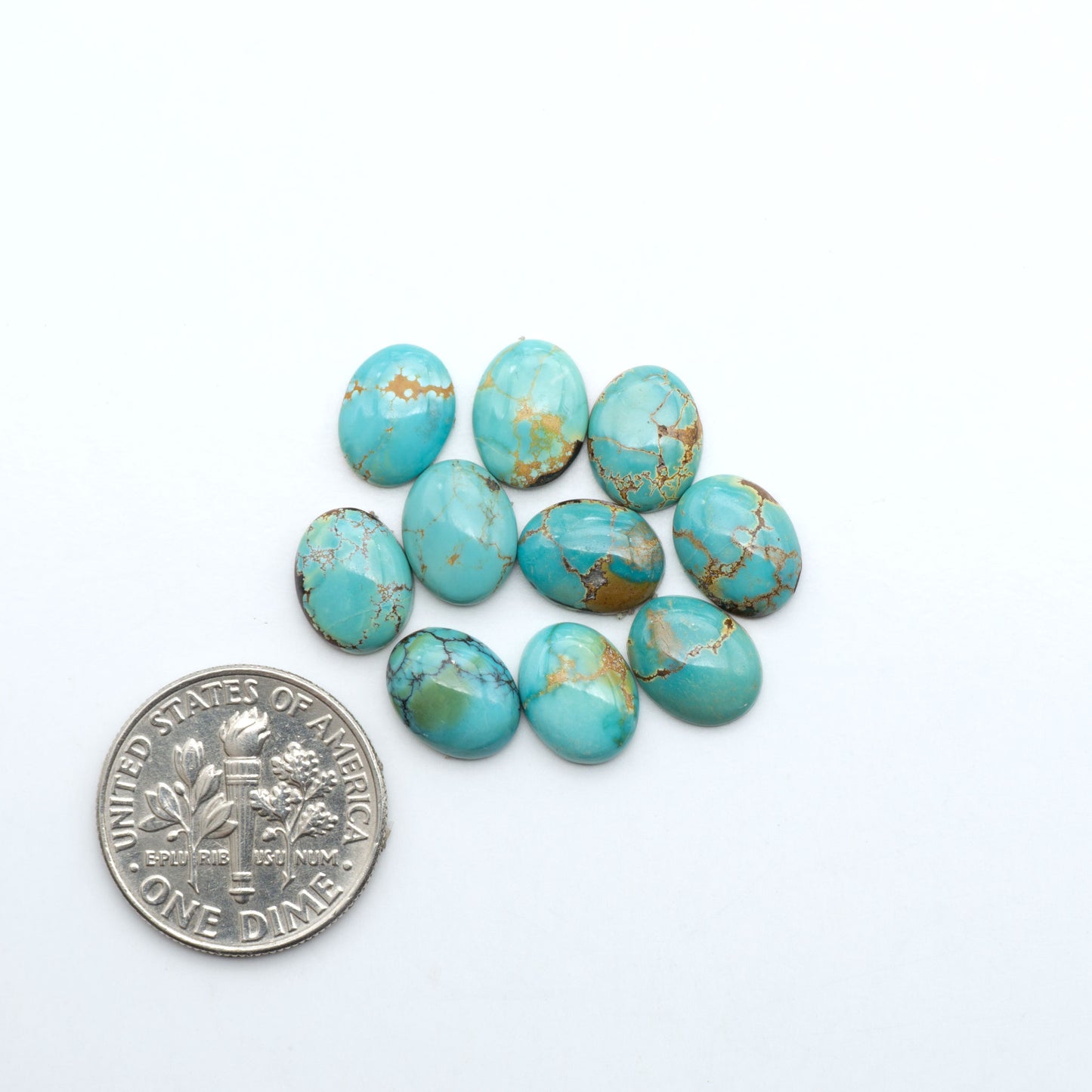 Hubei Cloud Mountain Turquoise cabochons, blue and green color with black matrix, polished stones on a white background with a US dime for scale