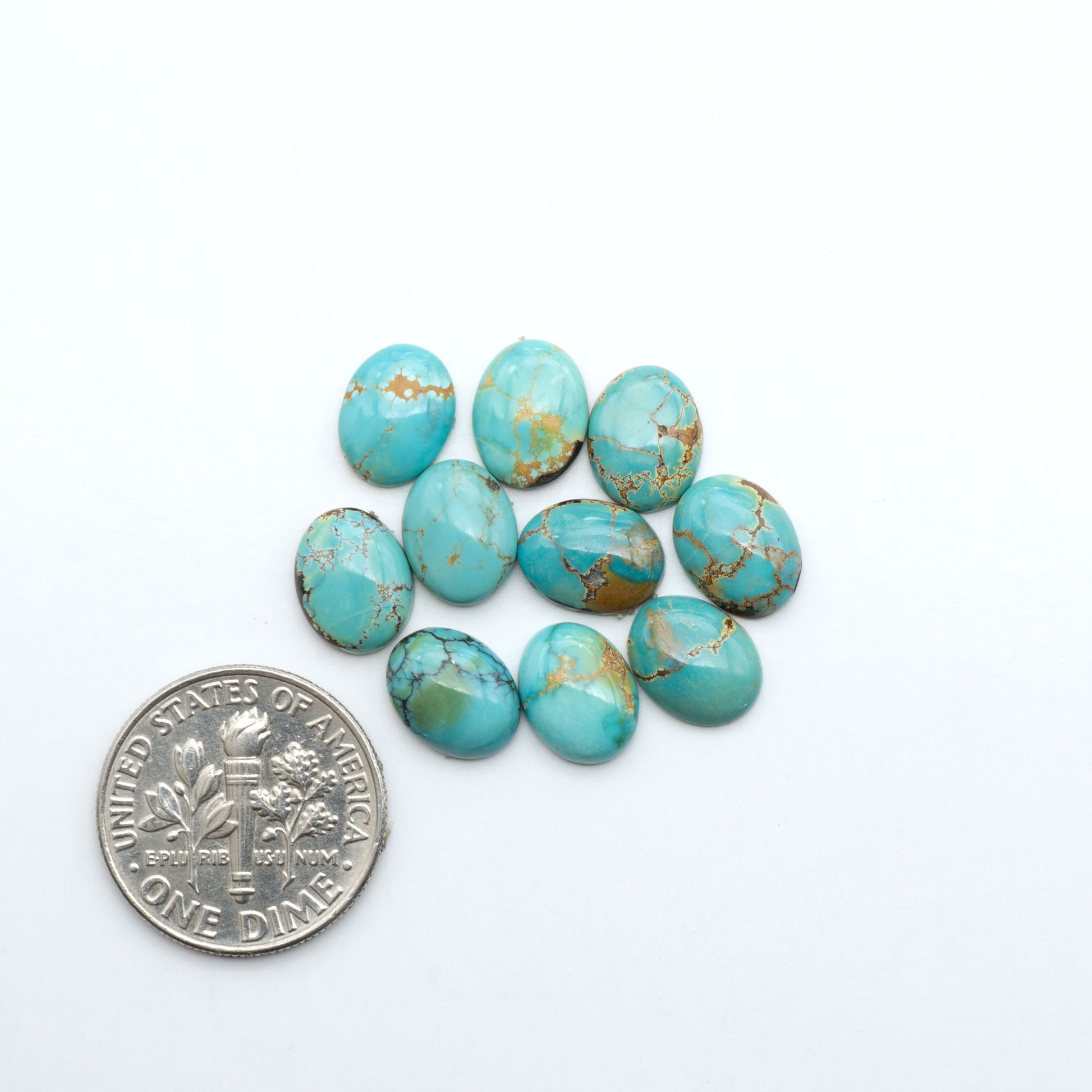 Hubei Cloud Mountain Turquoise cabochons, blue and green color with black matrix, polished stones on a white background with a US dime for scale