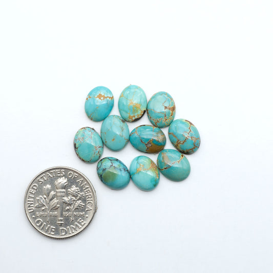 Hubei Cloud Mountain Turquoise cabochons, blue and green color with black matrix, polished stones on a white background with a US dime for scale