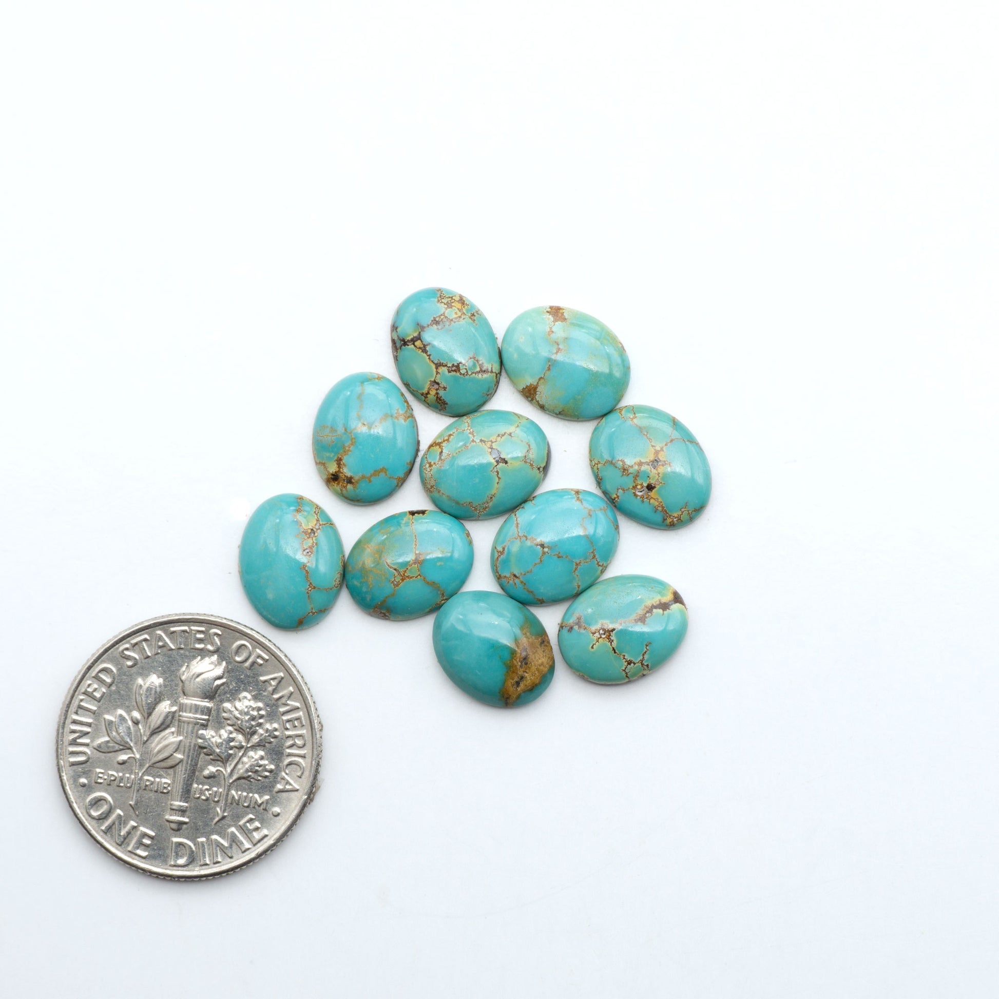 Hubei Cloud Mountain Turquoise cabochons, blue and green color with black matrix, polished stones on a white background with a US dime for scale