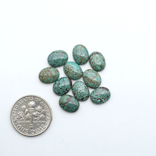 Hubei Cloud Mountain Turquoise cabochons, blue and green color with black matrix, polished stones on a white background with a US dime for scale