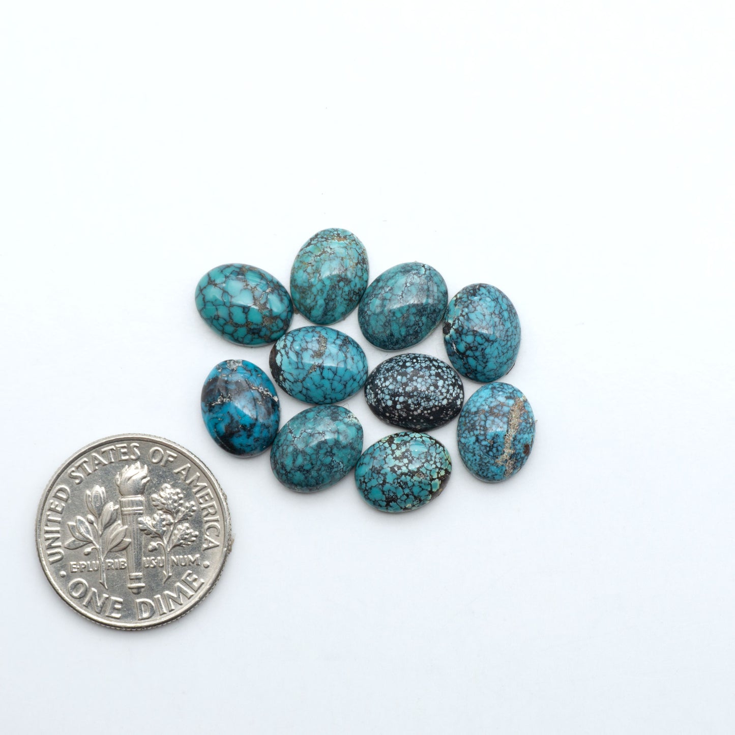 Hubei Cloud Mountain Turquoise cabochons, blue and green color with black matrix, polished stones on a white background with a US dime for scale