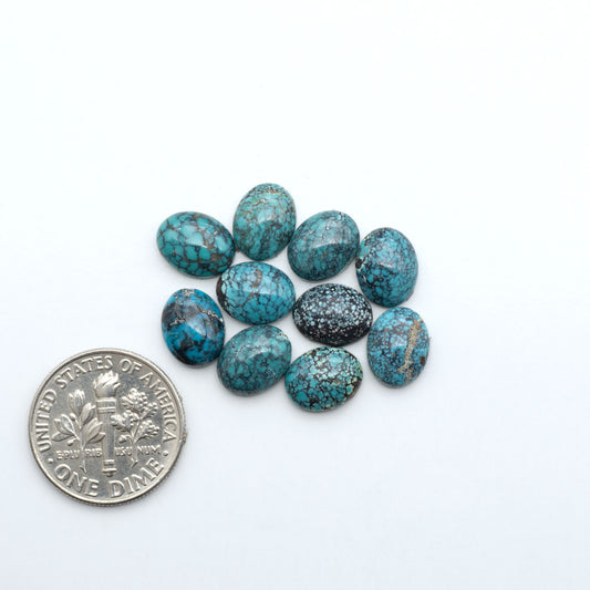 Hubei Cloud Mountain Turquoise cabochons, blue and green color with black matrix, polished stones on a white background with a US dime for scale