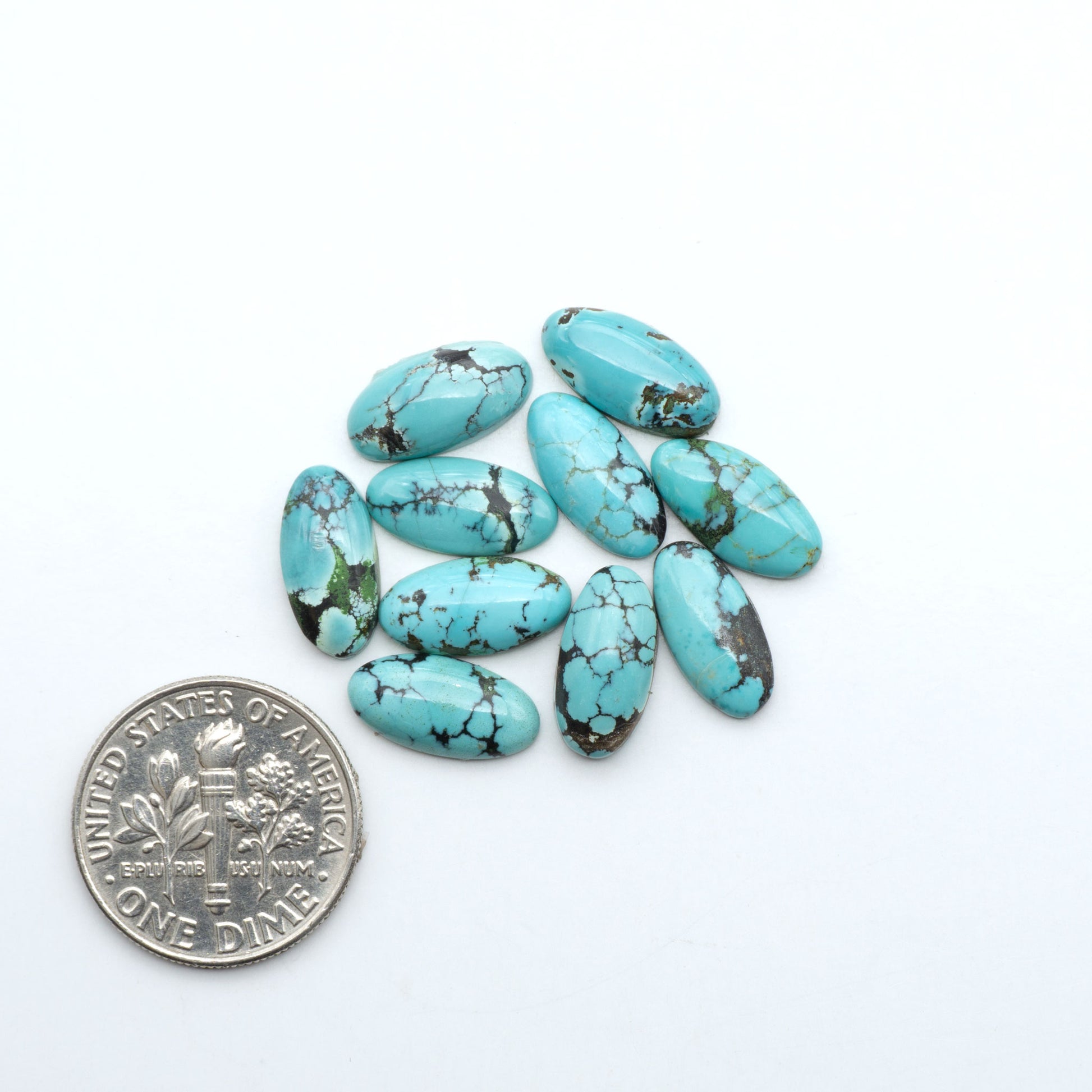 Hubei Cloud Mountain Turquoise cabochons, blue and green color with black matrix, polished stones on a white background with a US dime for scale