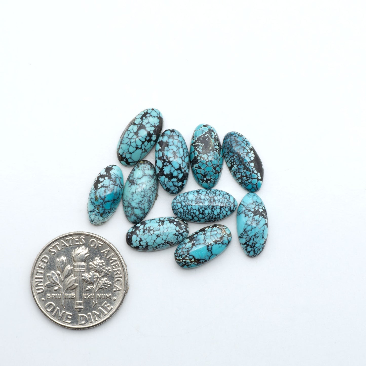 Hubei Cloud Mountain Turquoise cabochons, blue and green color with black matrix, polished stones on a white background with a US dime for scale