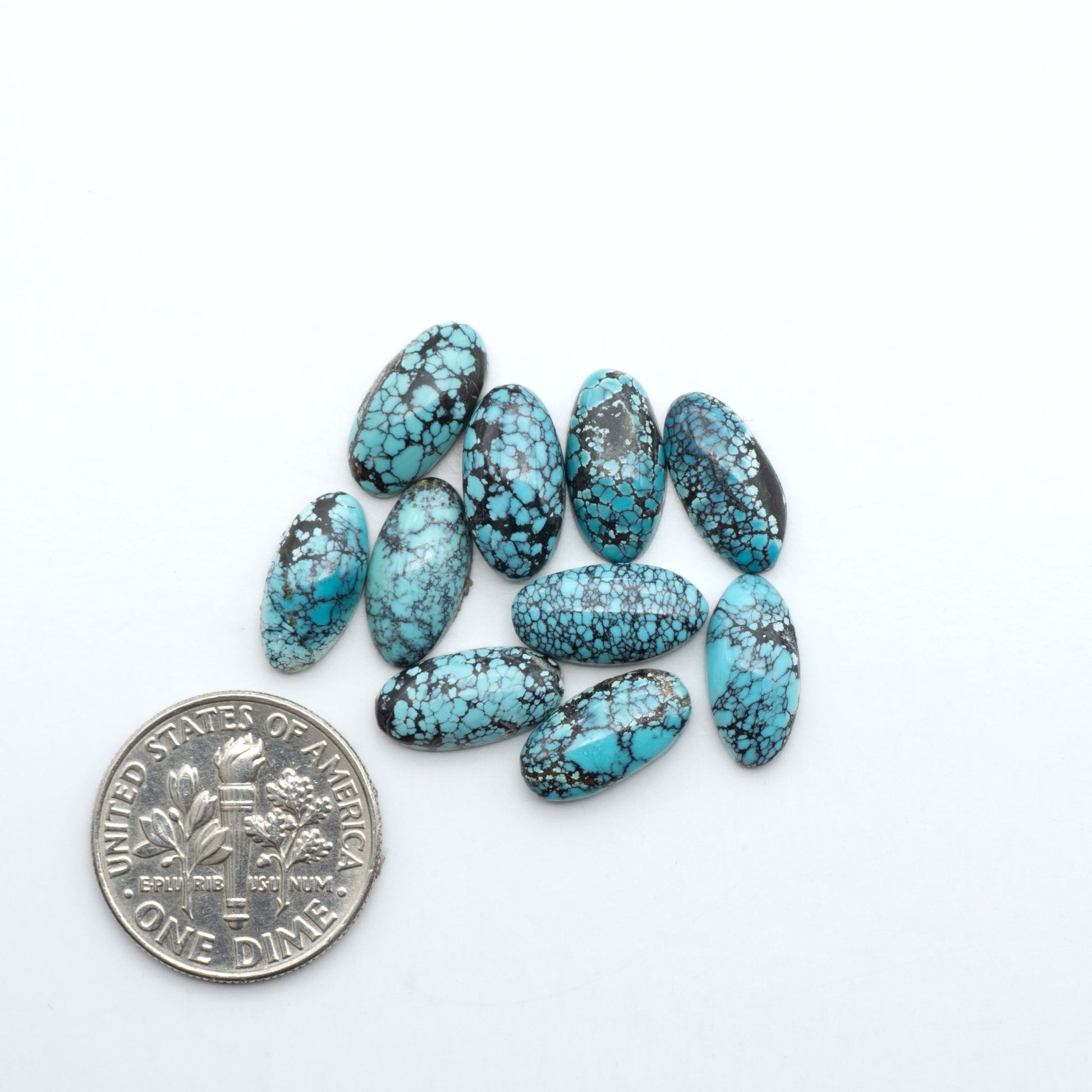 Hubei Cloud Mountain Turquoise cabochons, blue and green color with black matrix, polished stones on a white background with a US dime for scale