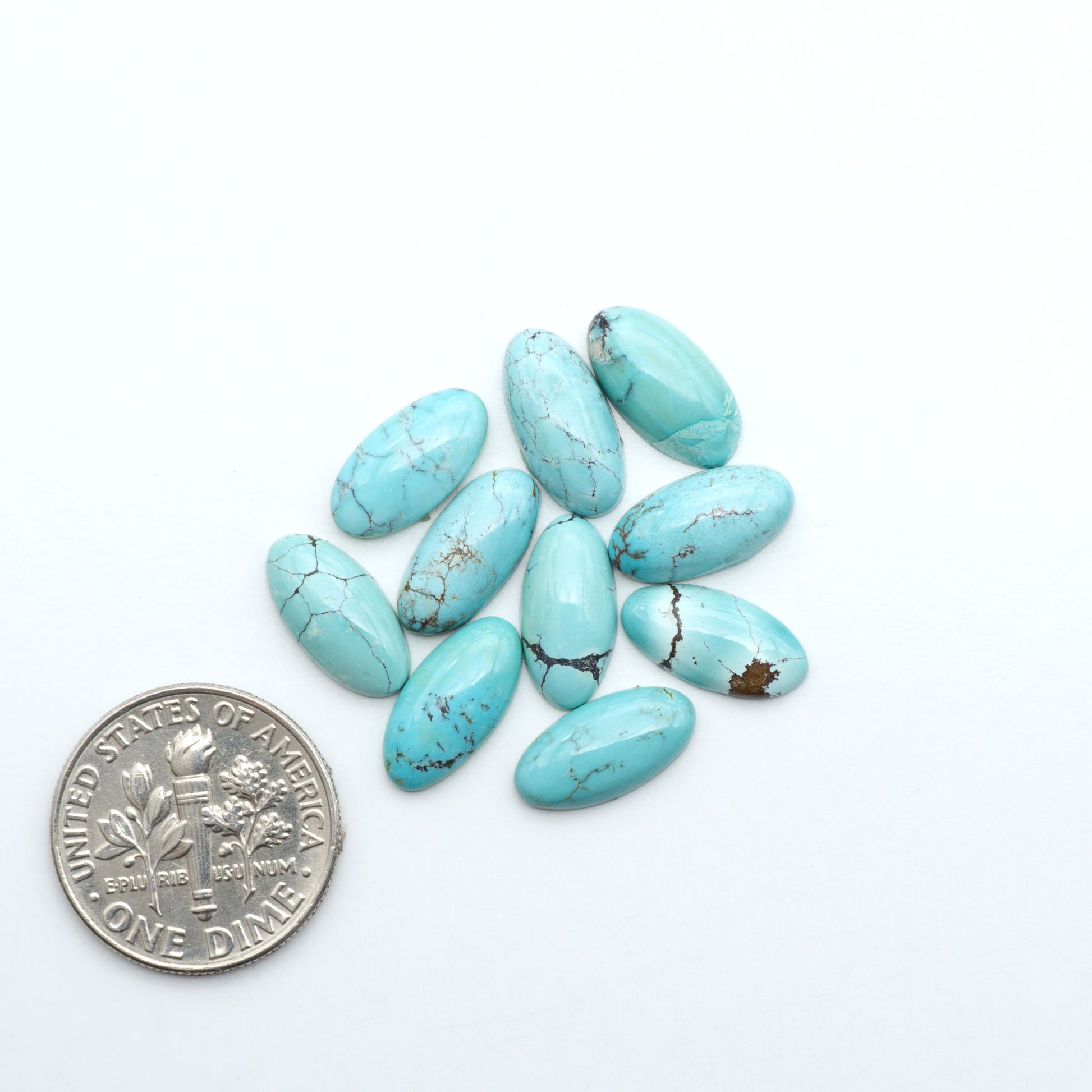 Hubei Cloud Mountain Turquoise cabochons, blue and green color with black matrix, polished stones on a white background with a US dime for scale