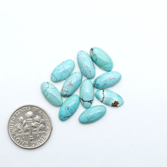 Hubei Cloud Mountain Turquoise cabochons, blue and green color with black matrix, polished stones on a white background with a US dime for scale