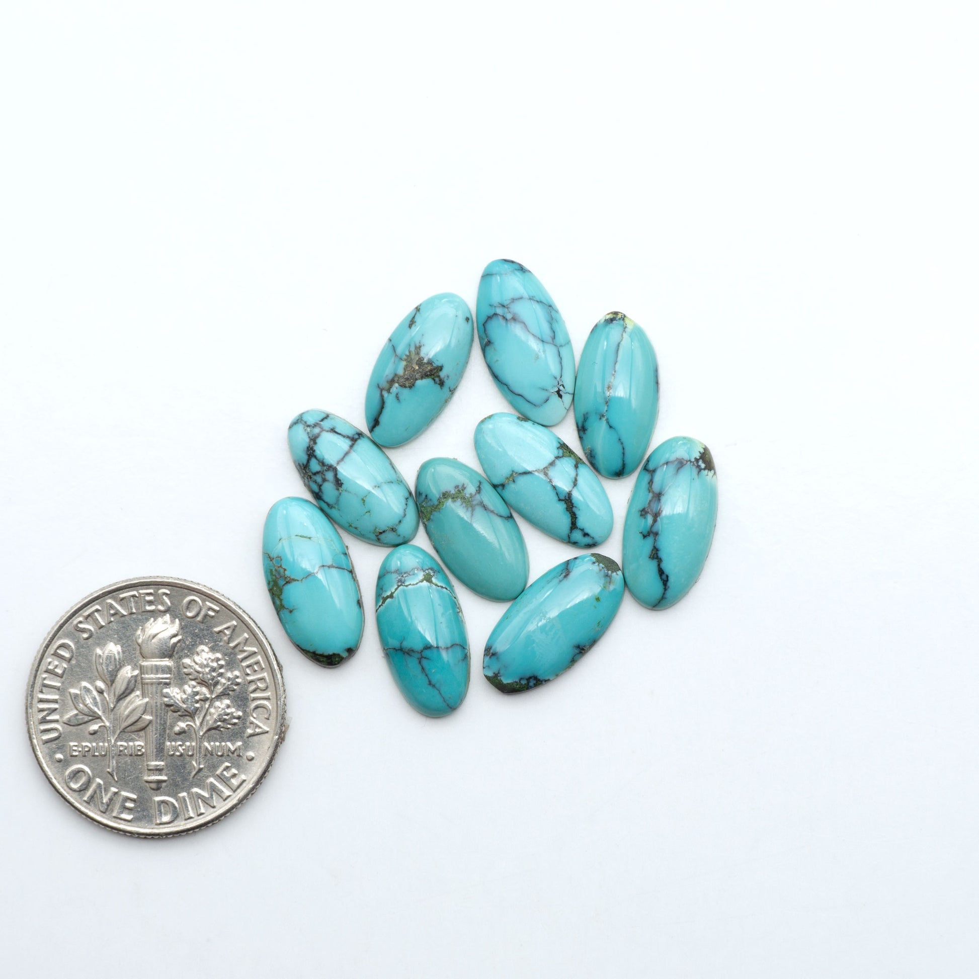 Hubei Cloud Mountain Turquoise cabochons, blue and green color with black matrix, polished stones on a white background with a US dime for scale