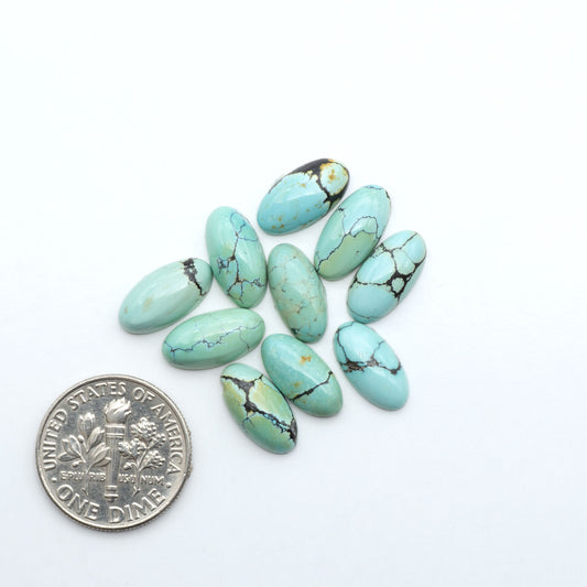 Hubei Cloud Mountain Turquoise cabochons, blue and green color with black matrix, polished stones on a white background with a US dime for scale