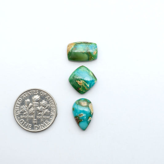 Sonoran Mountain Turquoise cabochons, blue-green color with natural matrix, polished stones on a white background, with a US dime for scale
