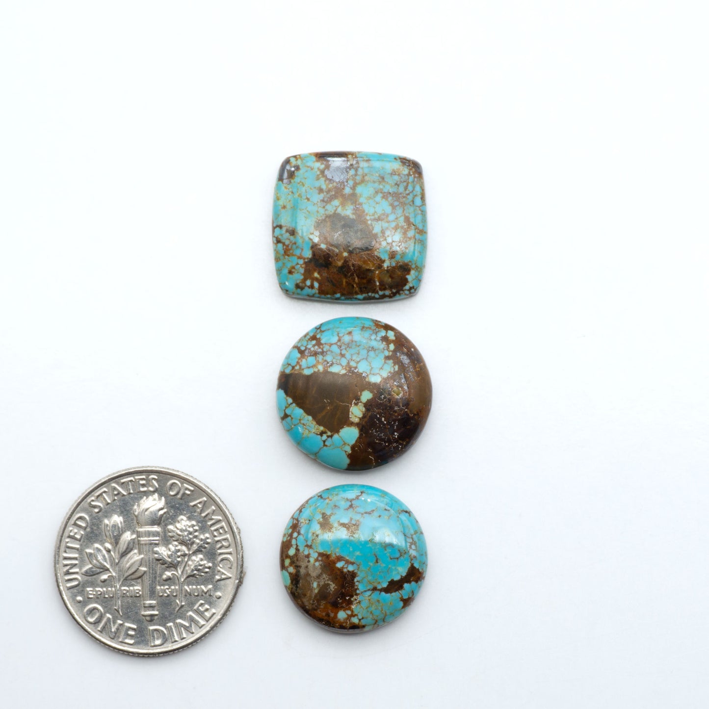Number 8 Turquoise cabochons, blue and green color with brown matrix, polished stones on a white background, with a US dime for scale