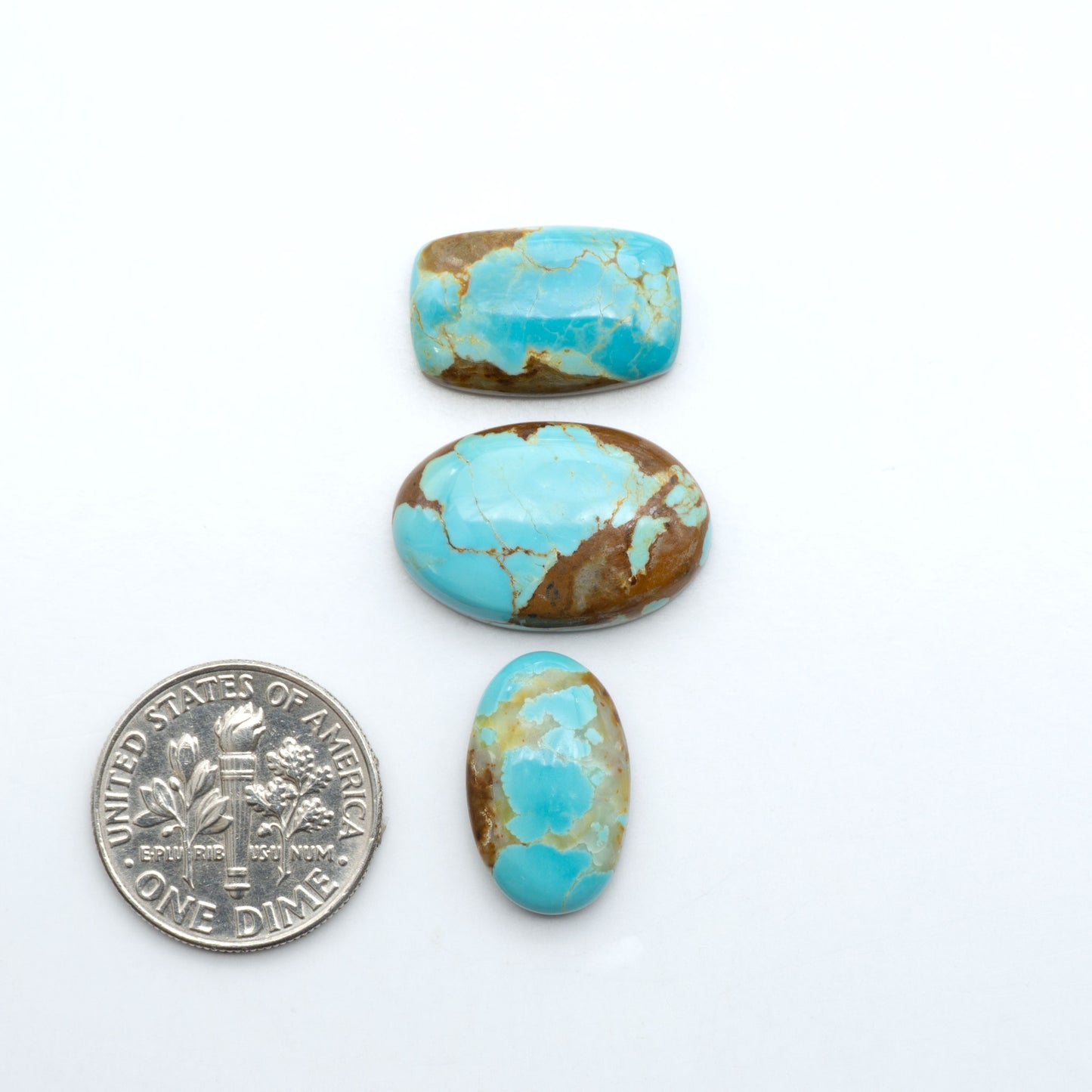 Number 8 Turquoise cabochons, blue and green color with brown matrix, polished stones on a white background, with a US dime for scale