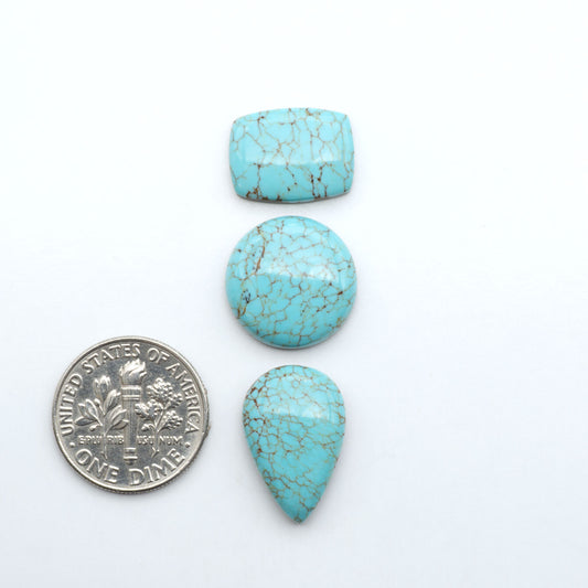 Number 8 Turquoise cabochons, blue and green color with brown matrix, polished stones on a white background, with a US dime for scale
