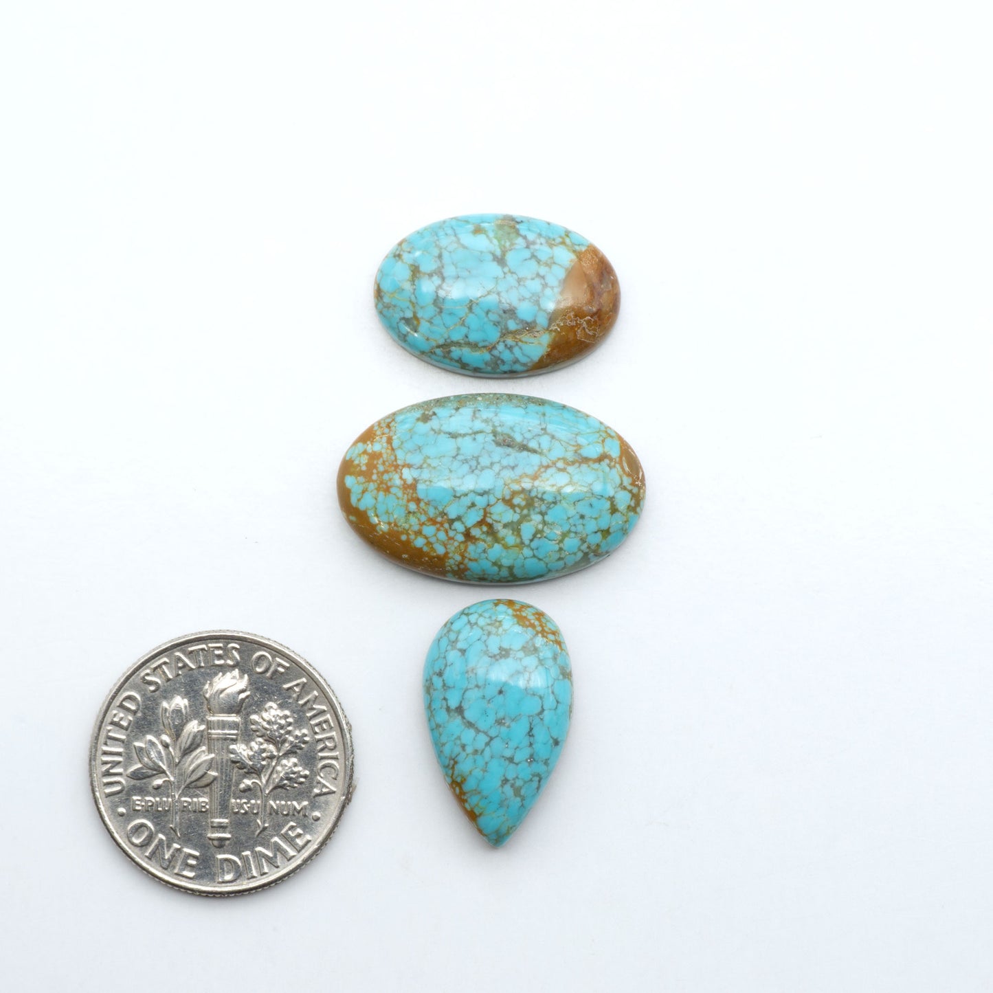 Number 8 Turquoise cabochons, blue and green color with brown matrix, polished stones on a white background, with a US dime for scale