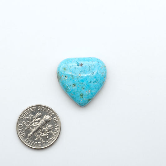Nacozari Turquoise cabochons, blue to greenish-blue gemstones with black or brown matrix and pyrite on a white background with a US dime for scale