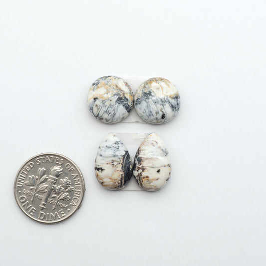 White Buffalo stone cabochons, white stone with black matrix, polished stones on a white background, with a US dime for scale
