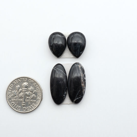 White Buffalo stone cabochons, white stone with black matrix, polished stones on a white background, with a US dime for scale
