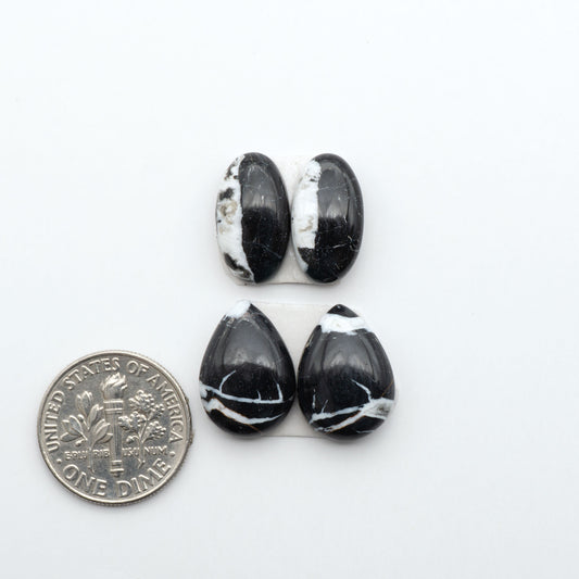 White Buffalo stone cabochons, white stone with black matrix, polished stones on a white background, with a US dime for scale