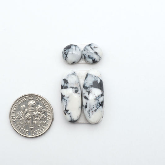 White Buffalo stone cabochons, white stone with black matrix, polished stones on a white background, with a US dime for scale