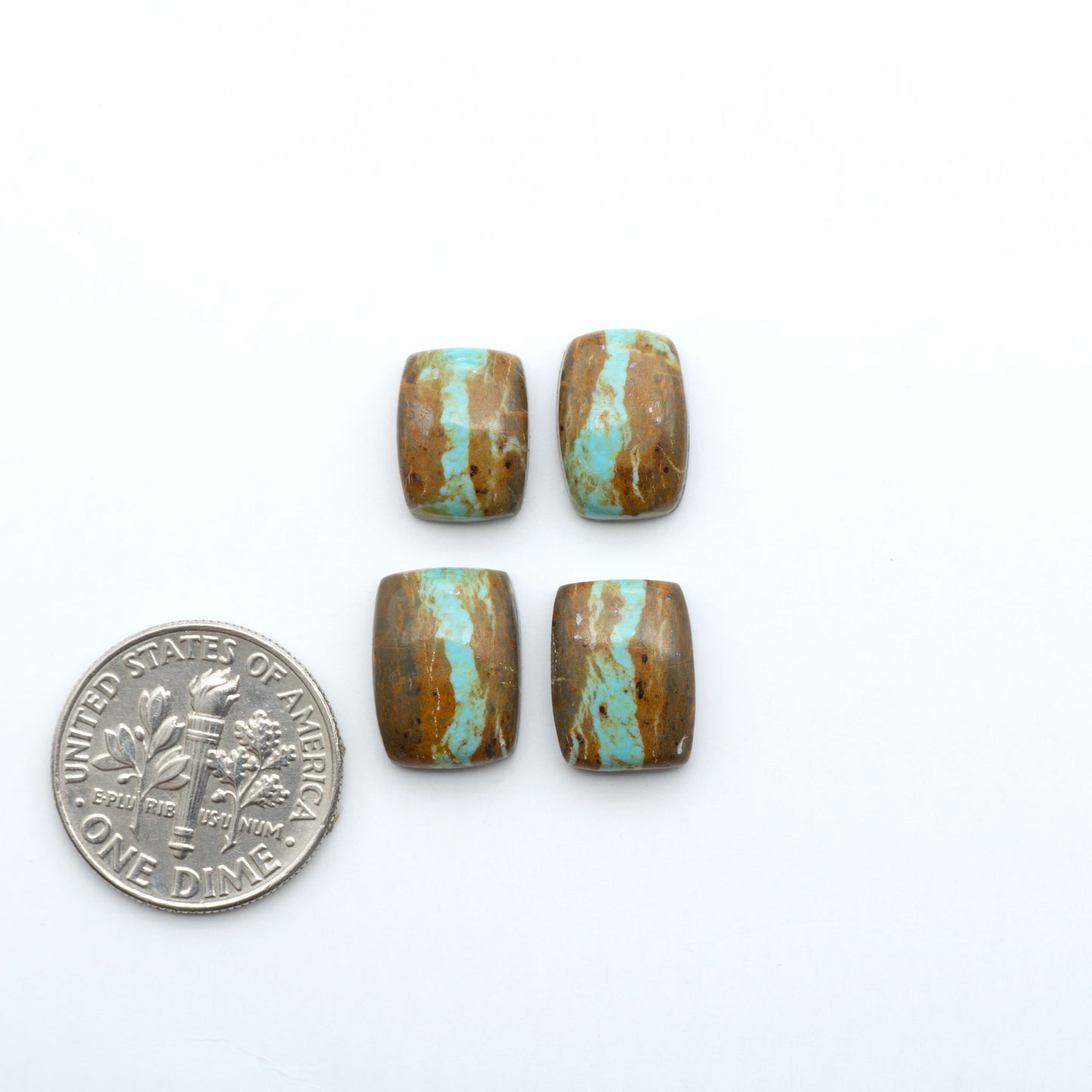 Number 8 Turquoise cabochons, blue and green color with brown matrix, polished stones on a white background, with a US dime for scale