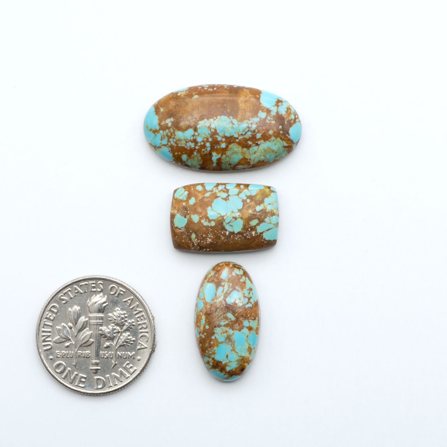 Number 8 Turquoise cabochons, blue and green color with brown matrix, polished stones on a white background, with a US dime for scale