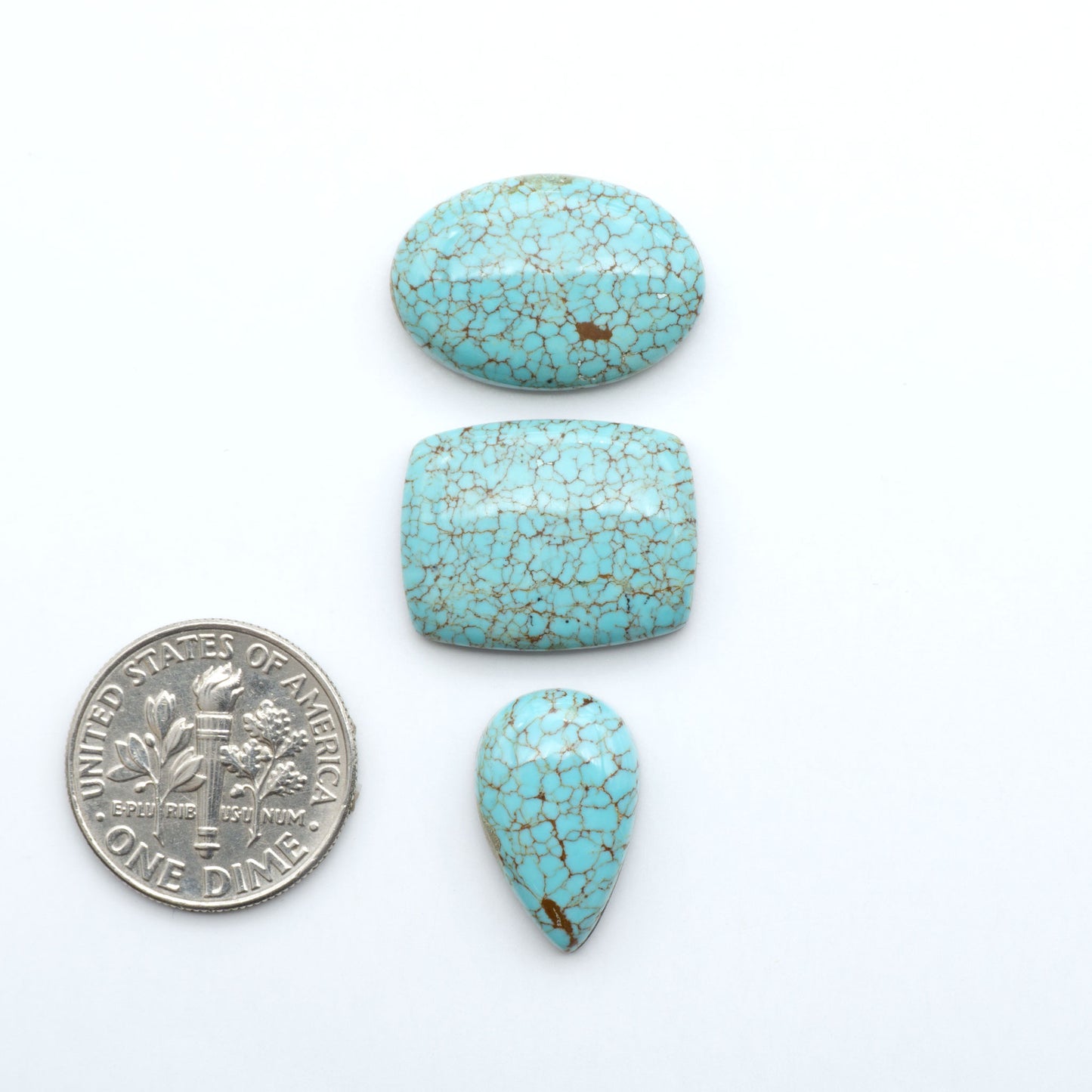 Number 8 Turquoise cabochons, blue and green color with brown matrix, polished stones on a white background, with a US dime for scale