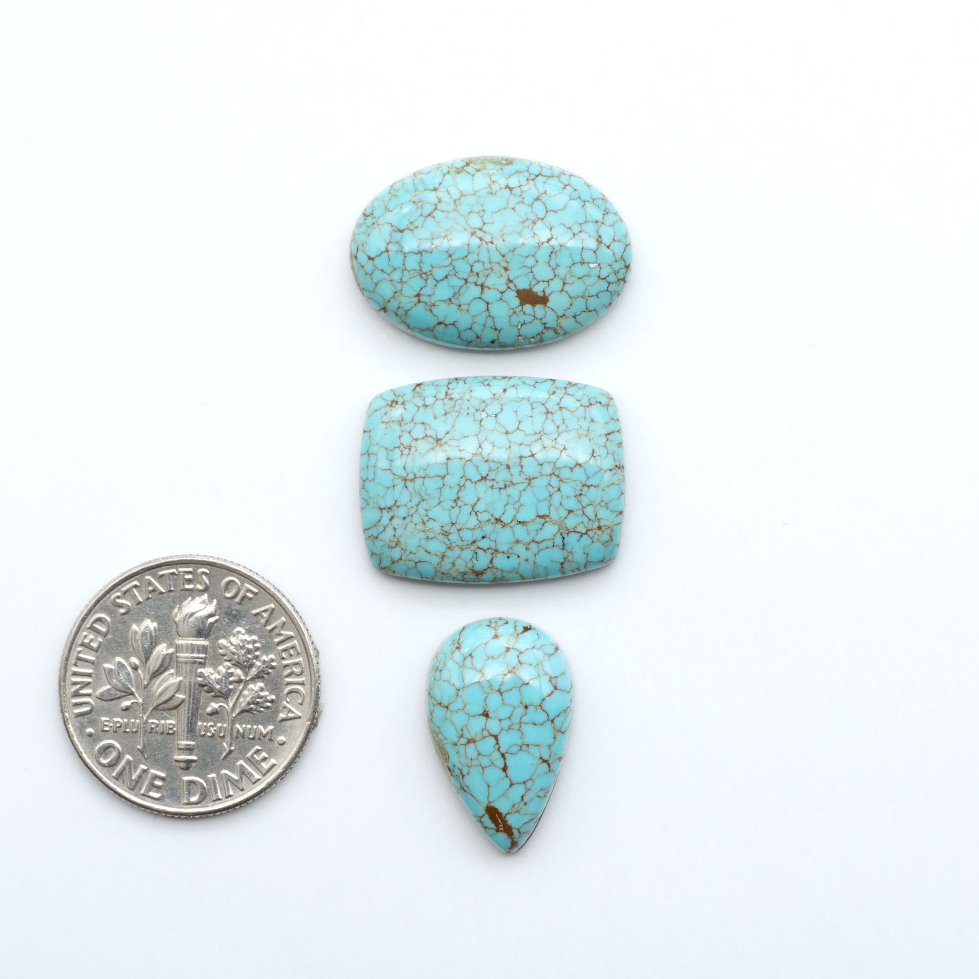 Number 8 Turquoise cabochons, blue and green color with brown matrix, polished stones on a white background, with a US dime for scale