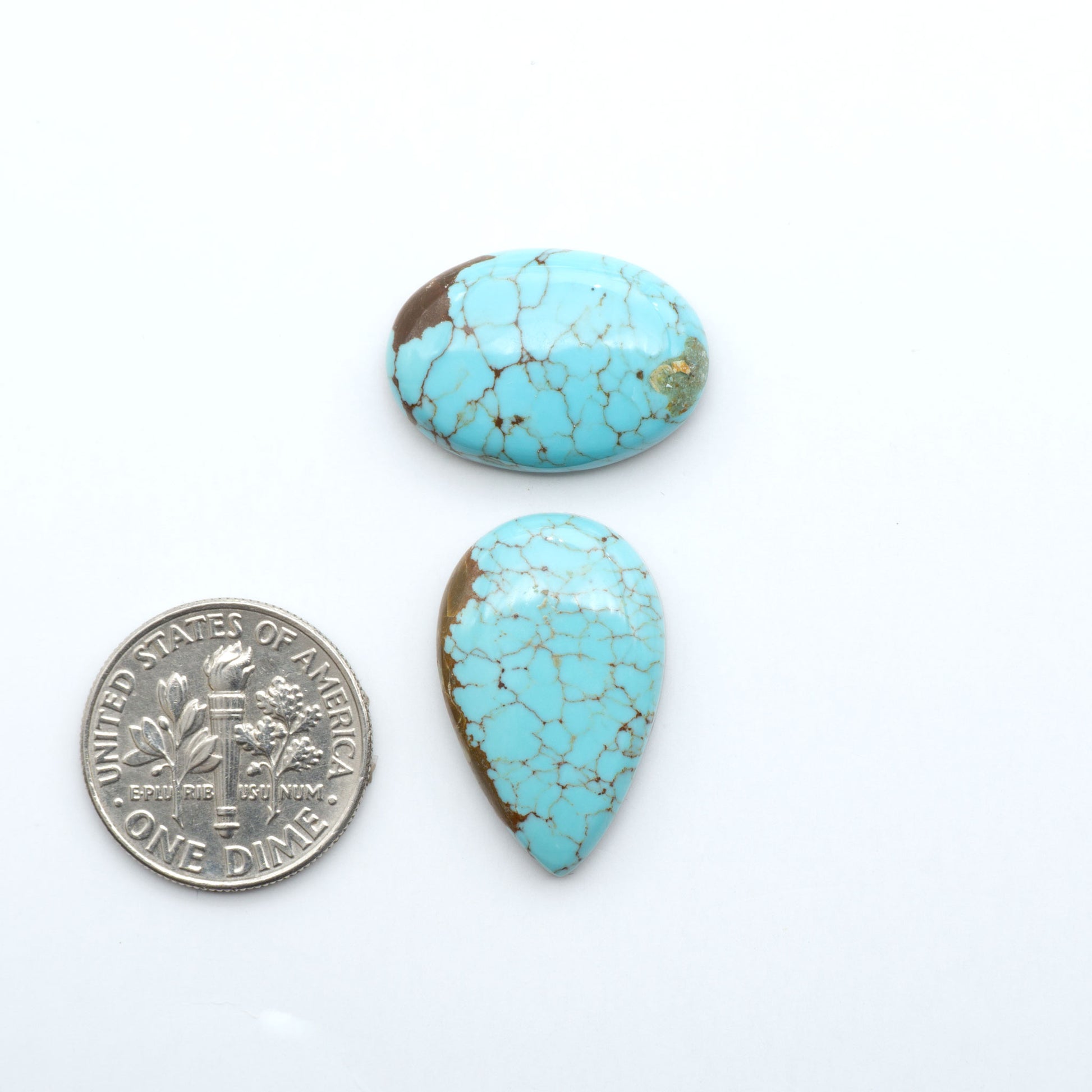Number 8 Turquoise cabochons, blue and green color with brown matrix, polished stones on a white background, with a US dime for scale