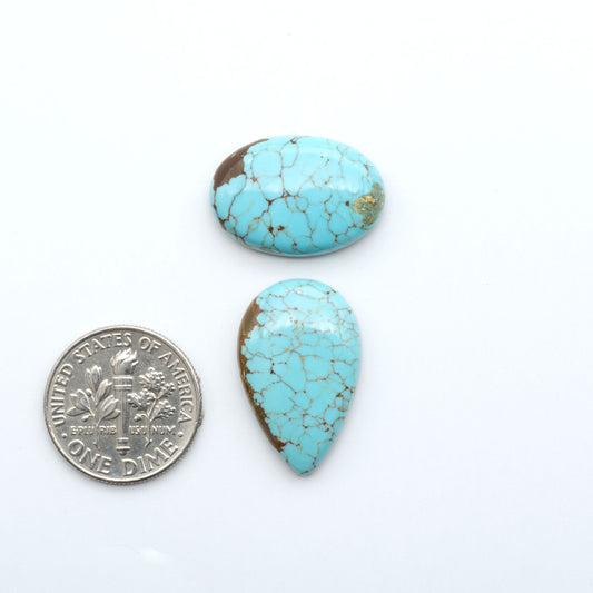Number 8 Turquoise cabochons, blue and green color with brown matrix, polished stones on a white background, with a US dime for scale