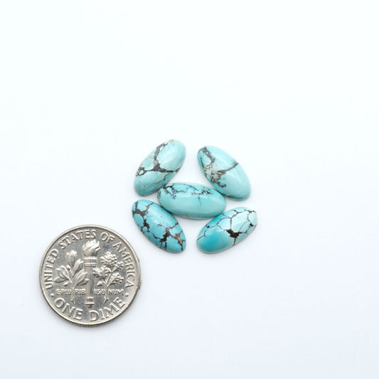Hubei Cloud Mountain Turquoise cabochons, blue and green color with black matrix, polished stones on a white background, with a US dime for scale