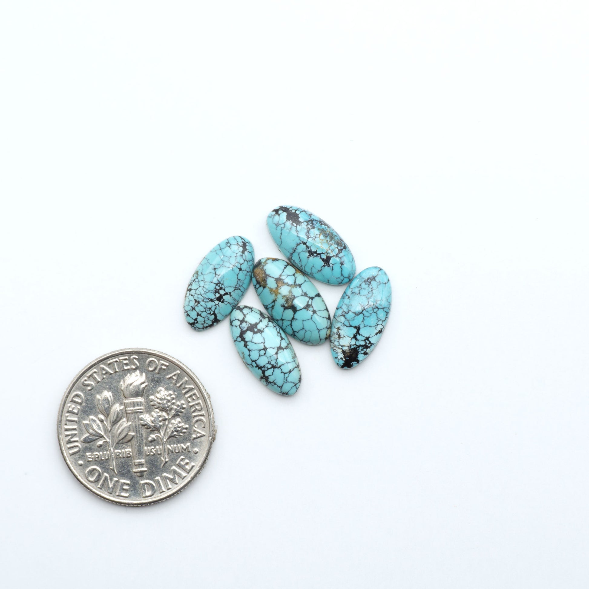 Hubei Cloud Mountain Turquoise cabochons, blue and green color with black matrix, polished stones on a white background, with a US dime for scale