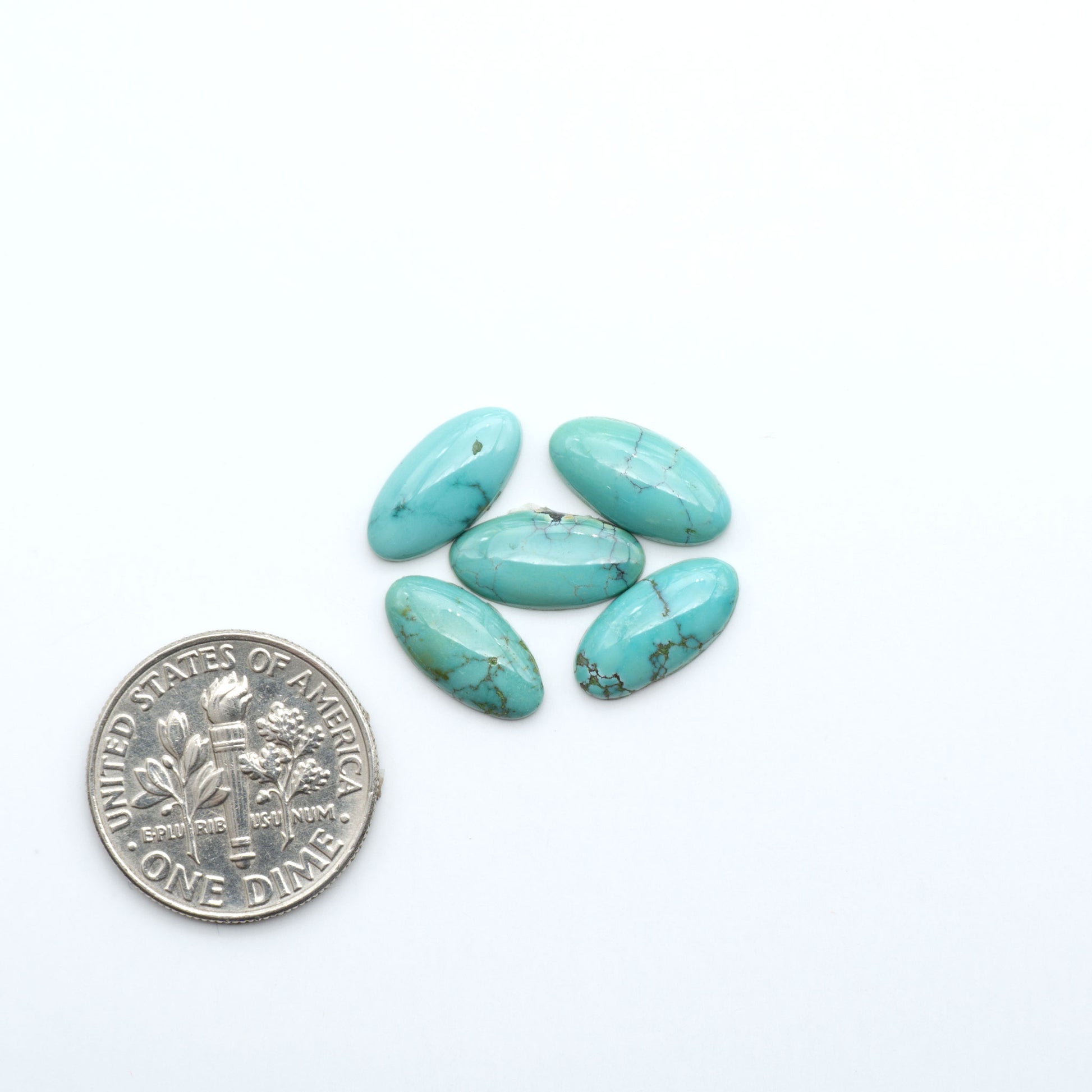 Hubei Cloud Mountain Turquoise cabochons, blue and green color with black matrix, polished stones on a white background, with a US dime for scale