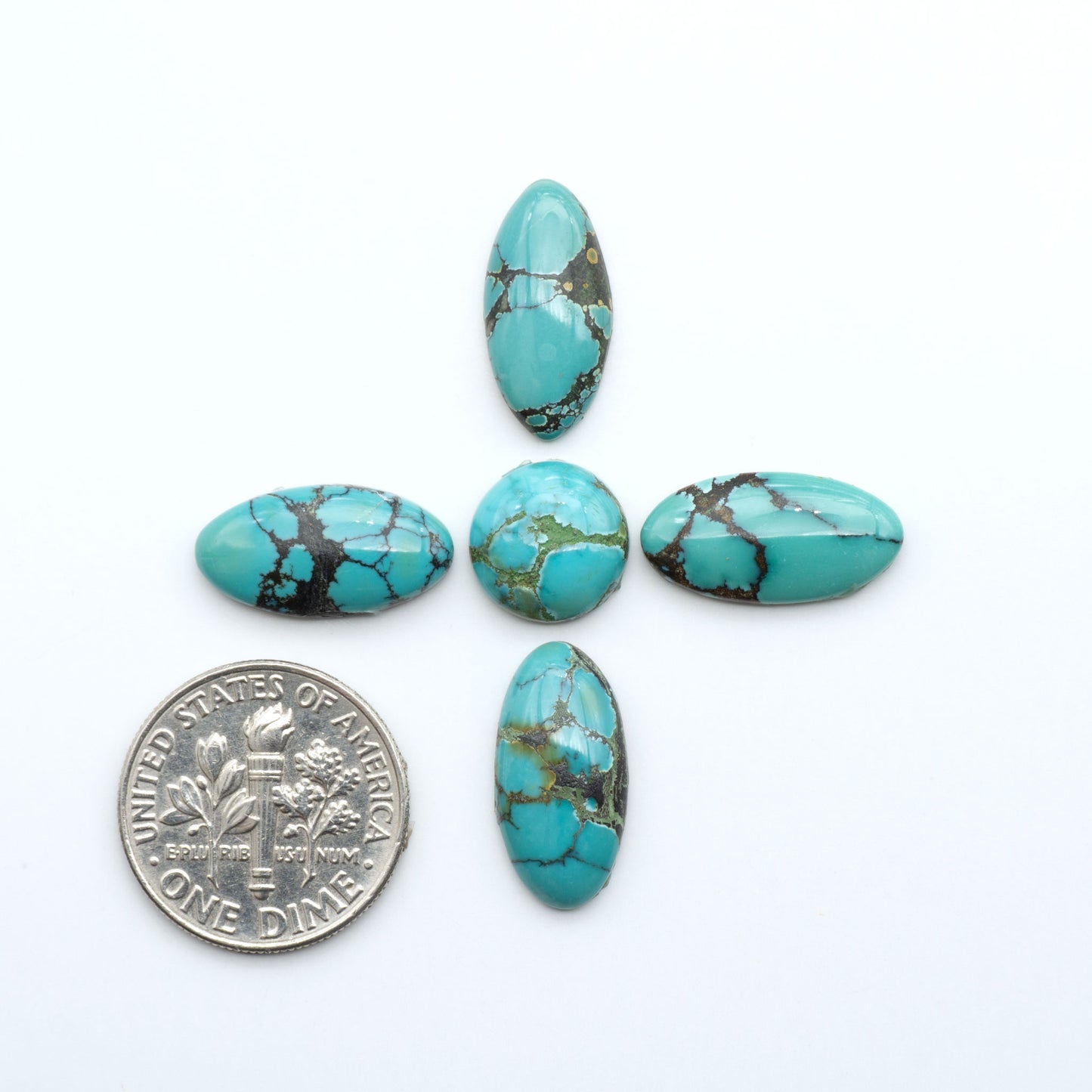 Hubei Cloud Mountain Turquoise cabochons, blue and green color with black matrix, polished stones on a white background, with a US dime for scale