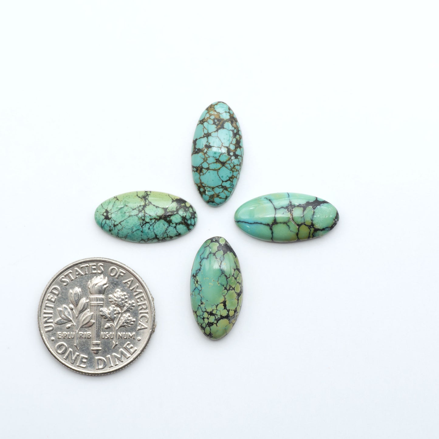 Hubei Cloud Mountain Turquoise cabochons, blue and green color with black matrix, polished stones on a white background, with a US dime for scale
