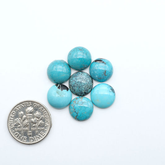Hubei Cloud Mountain Turquoise cabochons, blue and green color with black matrix, polished stones on a white background, with a US dime for scale