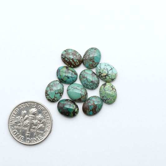 Hubei Cloud Mountain Turquoise cabochons, blue and green color with black matrix, polished stones on a white background, with a US dime for scale