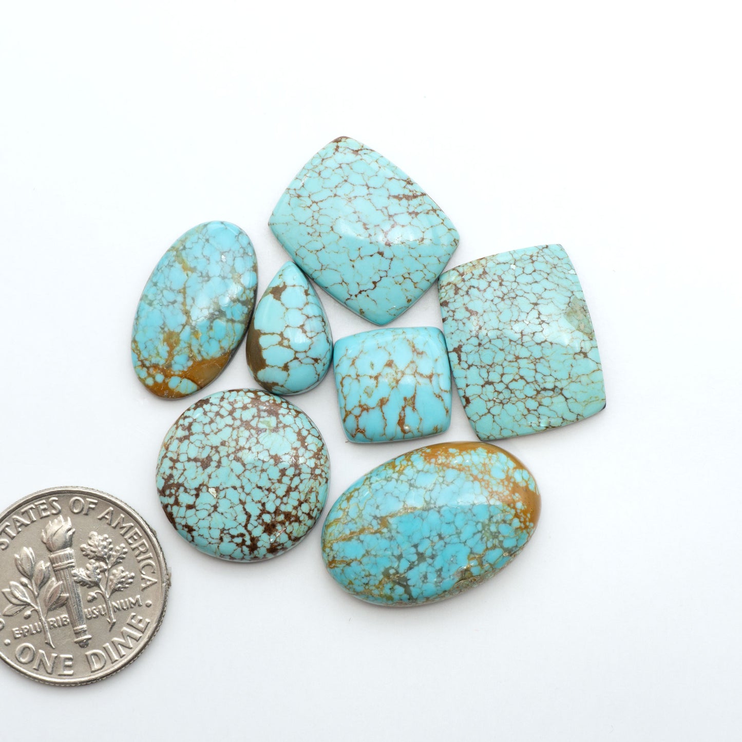 Number 8 Turquoise cabochons, blue and green color with brown matrix, polished stones on a white background, with a US dime for scale
