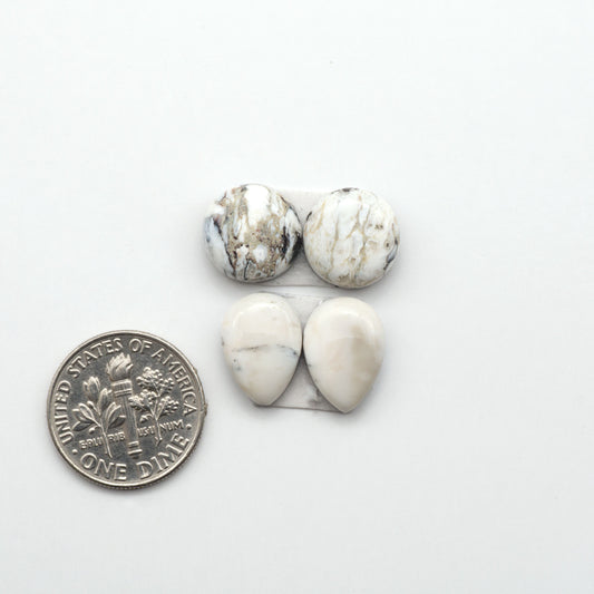 White Buffalo stone cabochons, white stone with black matrix, polished stones on a white background, with a US dime for scale