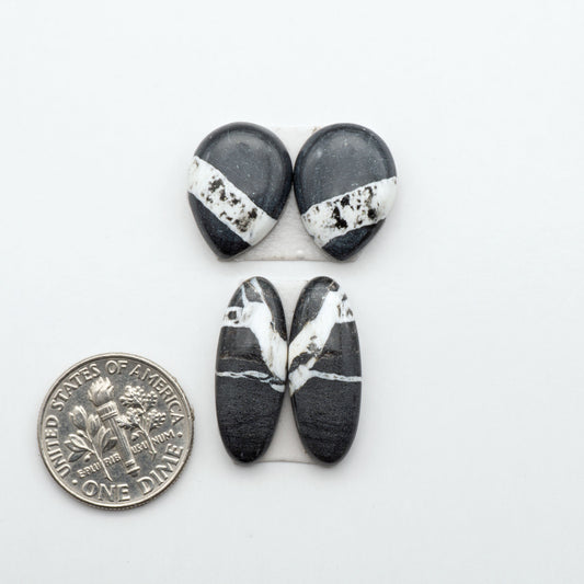White Buffalo stone cabochons, white stone with black matrix, polished stones on a white background, with a US dime for scale