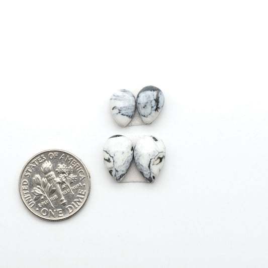 White Buffalo stone cabochons, white stone with black matrix, polished stones on a white background, with a US dime for scale