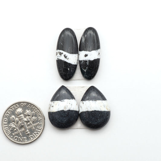 White Buffalo stone cabochons, white stone with black matrix, polished stones on a white background, with a US dime for scale